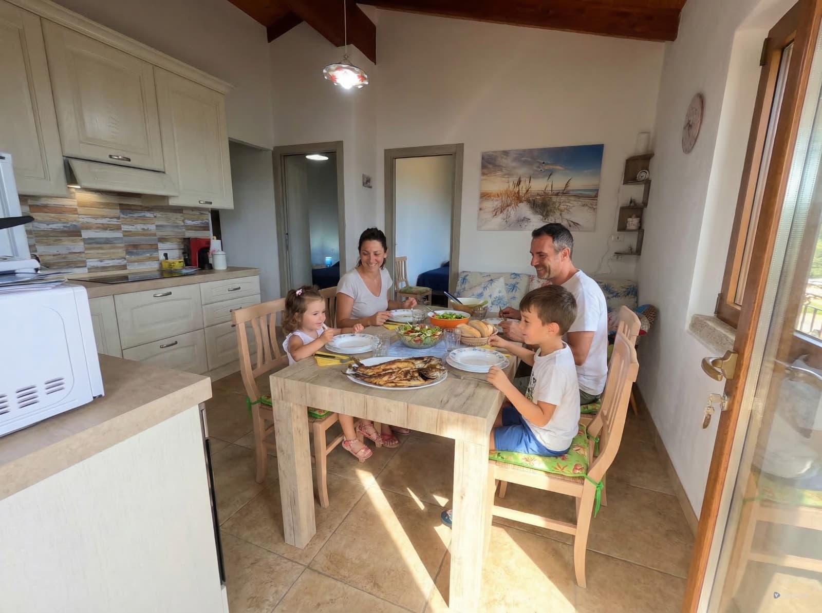 Soggiorno con cucina attrezzata e zona pranzo di VillaDea.